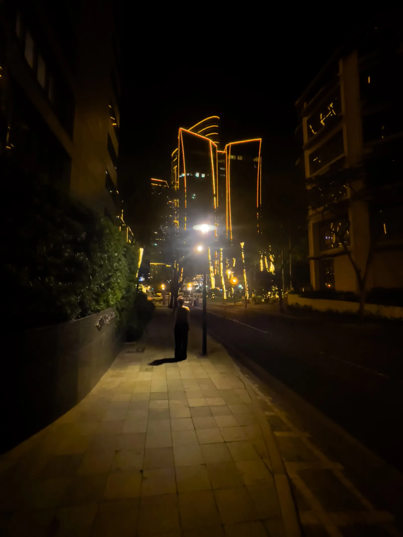 Narrow illuminated pedestrian alley with modern buildings